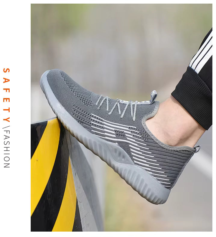 Grey steel toe cap safety sneaker worn on industrial railing — side view showing mesh upper and rubber sole grip